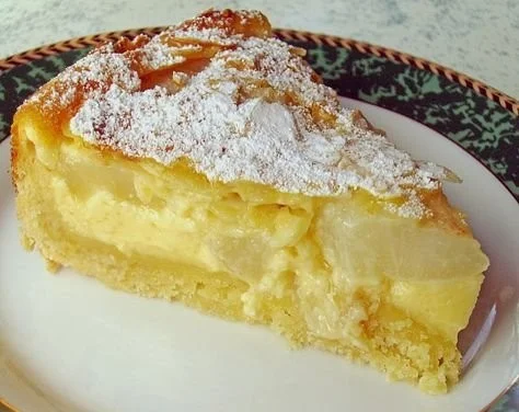 Birnenkuchen mit Vanilleguss auf einem Teller serviert