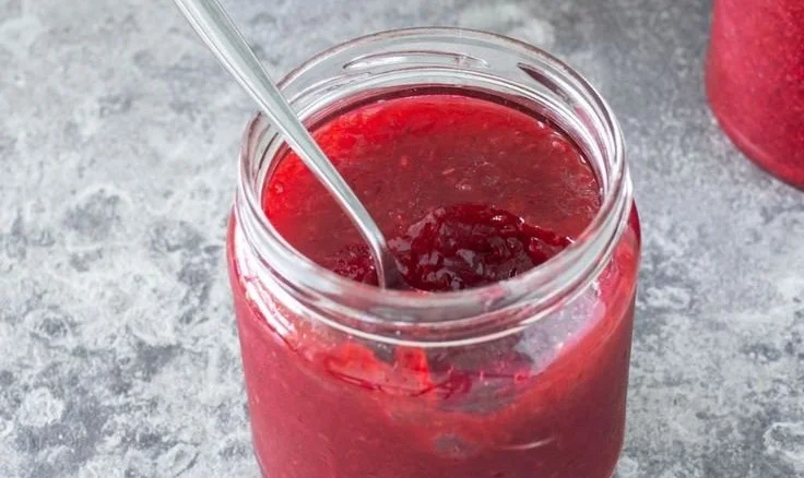 Glas mit hausgemachter Johannisbeer Marmelade auf einem Tisch