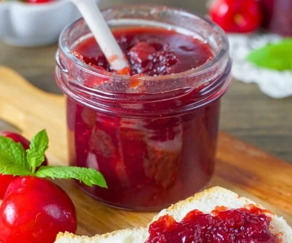Hausgemachte Kirschmarmelade mit frischer Minze im Glas