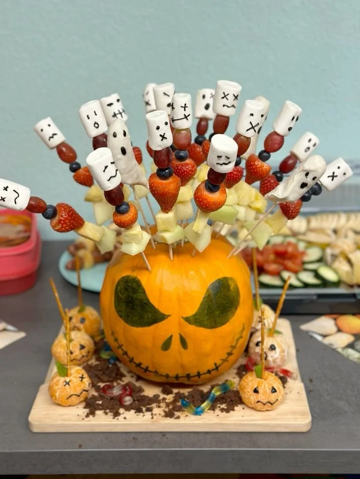 Bunter Obstspieß mit Kürbis dekoriert für Halloween-Feierlichkeiten