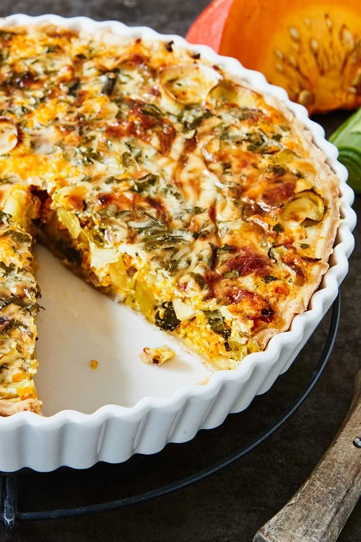 Saftige Kürbis-Lauchquiche mit goldbraunem Teig und frischem Gemüse.