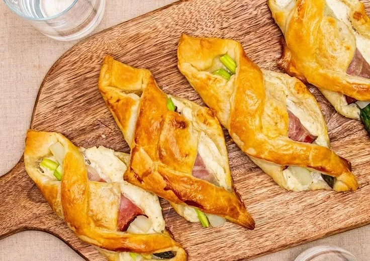 Spargel-Blätterteig-Taschen mit Schinken auf einem Teller angerichtet