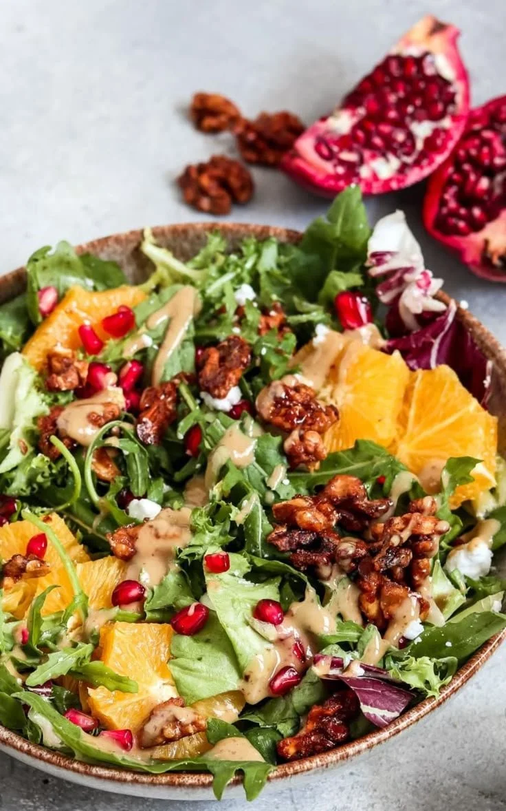 Leckere Wintersalat mit Granatapfel und Orangen auf einem Teller.